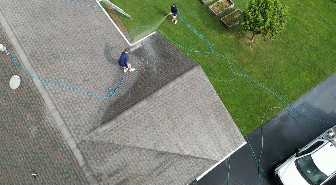 Coastal Shine roof cleaning in Easton MD: two technicians soft washing a shingle roof, seen from above